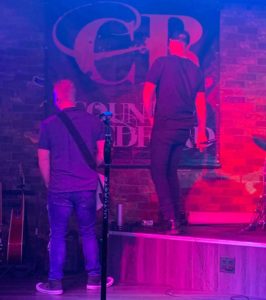 Disgruntled musicians urinate on own sign mid show